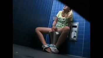 Rubia caliente pillada dedeandose duro en un baño publico